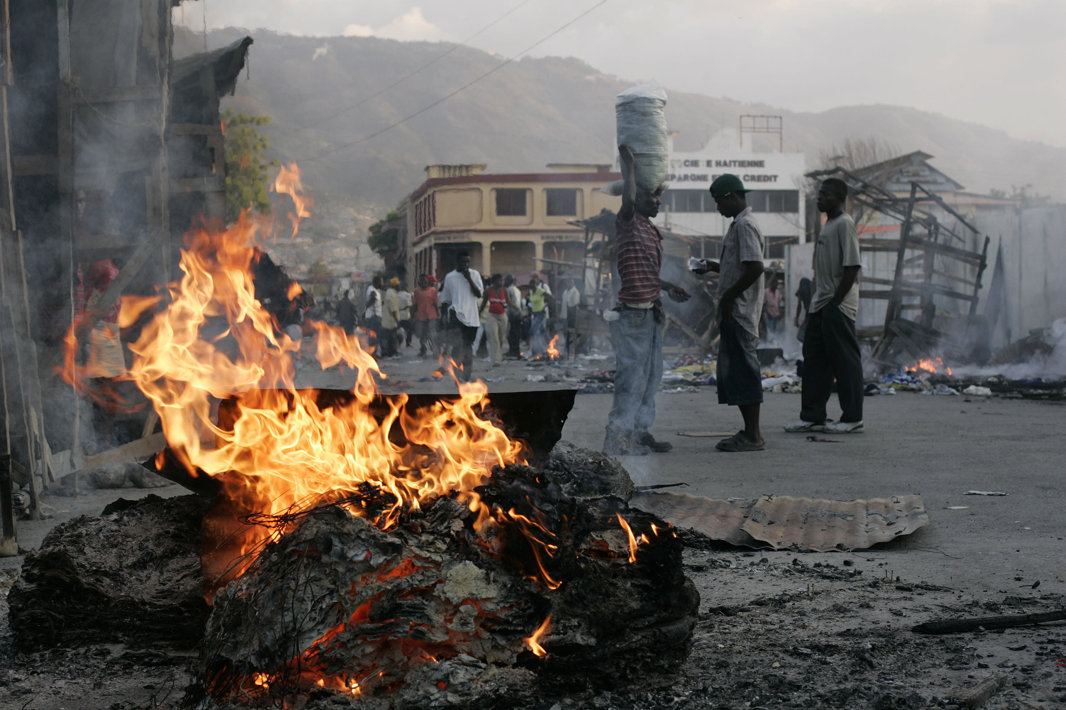A Haitian sells water next to a destroyed street market in downtown Port-au-Prince